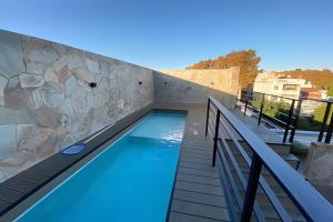罗萨里奥Estudio Ejecutivo con Amenities的一个带石墙的阳台的游泳池