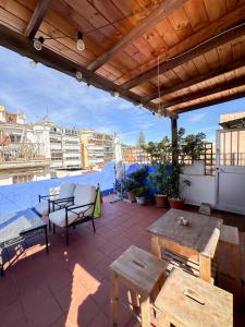 马拉加Beach House Málaga的屋顶上设有桌子和长凳的庭院