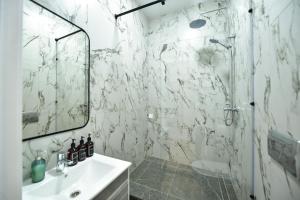 巴甫洛达尔SAFIA Hotel的带淋浴和盥洗盆的白色浴室
