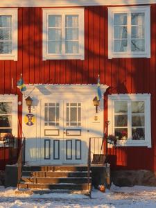 永比Södra Ljunga Vandrarhem的前面有楼梯的红色房子