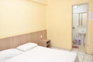 阿雷格里港Hotel Manoá Poa的卧室配有白色的床和水槽