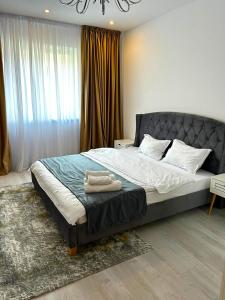 布加勒斯特YamaLuxe Apartments - Silent & Warm With Many Facilities的一间卧室配有一张床,上面有两条毛巾