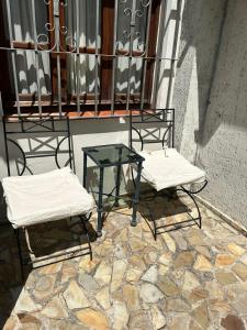 萨尔塔Ahicito - Casa en Tres Cerritos的阳台上配有两把椅子和一张玻璃桌