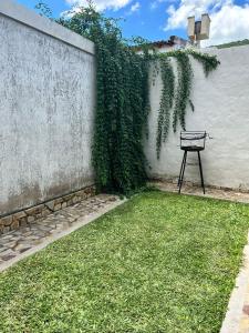 萨尔塔Ahicito - Casa en Tres Cerritos的坐在墙上的草上长凳