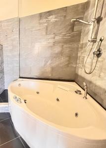 阿普里利亚Casa Pavone的带淋浴的浴室配有白色浴缸。