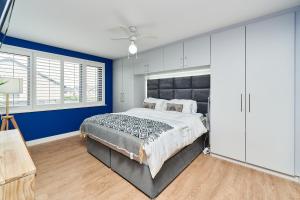 都柏林Modern Clonsilla Townhouse Sleeps 6的一间卧室设有一张大床和蓝色的墙壁