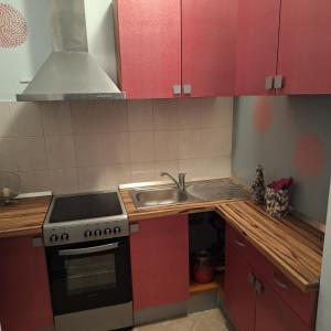 卡斯特罗诺维Mila的厨房配有红色橱柜、炉灶和水槽。