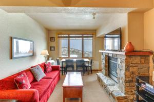 白鱼镇Whitefish Mountain Condo - Ski Resort On-Site!的客厅设有红色的沙发和壁炉