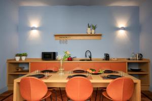 巴勒莫Maison Belmonte - Suites in Palermo的厨房配有木桌和橙色椅子