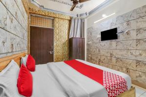 ChinhatFlagship Hotel Sai Palace Near Gomti Riverfront Park的一间卧室配有一张带红色枕头的床和一台电视。