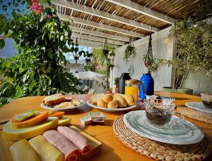 因比图巴Pousada Maria Parafina Praia do Rosa的一张木桌,上面有面包和食物