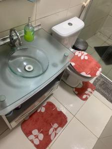 卡鲁阿鲁Quarto privativo Caruaru fácil acesso para o pátio de eventos e feira da sulanca的一间带水槽的浴室和一个带红色地毯的卫生间
