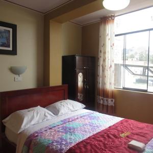 卡哈马卡Gran Hostal Los Pinos的一间卧室设有一张床和一个窗口