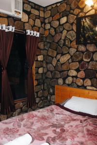 JhirnaCorbett Timlansh的一间卧室设有石墙、一张床和窗帘