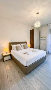 圣多纳托-米拉内塞Dream & Relax的卧室配有一张带吊灯的大型白色床。