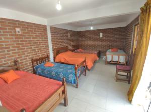 San JoséHospedaje Las Dalias的带三张床和砖墙的房间