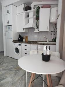 奇皮奥纳Apartamentos home Chipiona的白色的厨房配有白色的桌子和白色的橱柜
