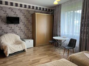 ChynadiyovoMini-Hotel "Nord"的一间卧室配有桌子、床和桌椅