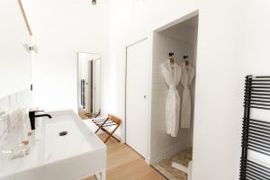 圣马迪拉莫Mas de la Fouque - Hôtel & Spa的白色的浴室设有水槽和镜子