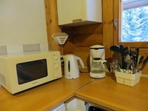 艾内科斯基Cottage-karaoke Koivikko的厨房柜台配有微波炉和电器。