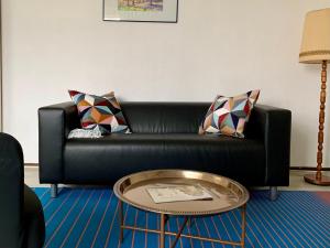 柏林威尔玛之家酒店的客厅里一张黑色皮沙发,配有桌子