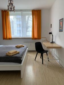 柏林威尔玛之家酒店的一间卧室配有一张床、一张桌子和一把椅子