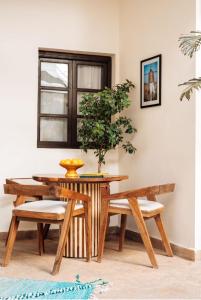 马拉喀什Riad Deha & Spa的餐桌和椅子,盆栽