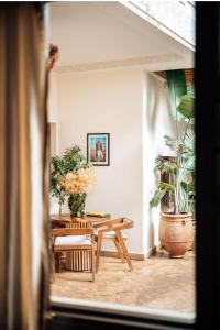 马拉喀什Riad Deha & Spa的配有桌椅和植物的房间