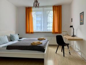 柏林威尔玛之家酒店的一间卧室配有带橙色窗帘的床和书桌