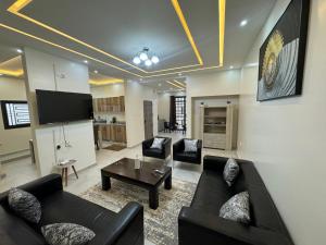 努瓦克肖特Complexe La Perfection的客厅配有两张黑色沙发和一台电视机
