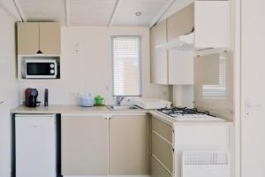 圣弗洛朗U Pezzo的白色的厨房配有白色橱柜和水槽