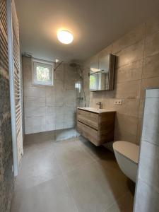 东卡佩勒Luxe lodges met airco的带浴缸、盥洗盆和卫生间的浴室