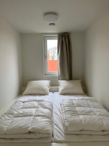东卡佩勒Luxe lodges met airco的一间卧室设有两张床和窗户。