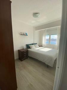 拉科鲁尼亚Apartamento Maresia的一间卧室设有一张床和一个窗口