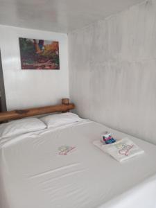 卡塔赫纳Venido del Mar Turquesa White Beach Barù的一张白色的床,上面有两条毛巾