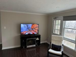 米西索加Enjoy luxury living的客厅配有平面电视和椅子。