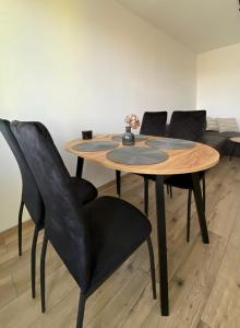 瓦乌布日赫Apartament Kasia的一张带黑色椅子的木桌和一张沙发