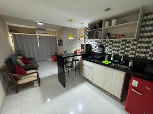 萨尔瓦多Ondina Apart Hotel Residences的厨房以及带沙发和台面的客厅。