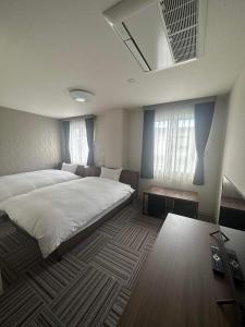 川口市WORLD ASAHI HOTEL的一间卧室设有一张大床和两个窗户。