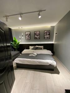 索瓦马San Vito Luxury apartment的一间卧室配有一张大床,墙上挂着一些图片
