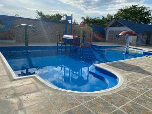 蒙特里亚hotel Vila orlanda finca hotel eventos的一个带滑梯的游乐场的游泳池