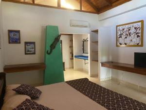 蒙特里亚hotel Vila orlanda finca hotel eventos的卧室配有一张床铺,墙上挂着绿色物品