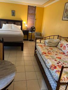 蒙特哥贝Sunny Tides at Montego Bay Club Resort的酒店客房设有一张床铺、一张桌子和一张桌子。