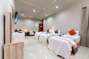乌库拉斯Palm Oasis at Ukulhas的客房设有几张床和一台平面电视。