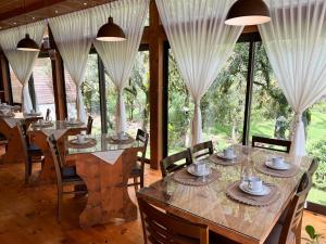 乌鲁比西Cabanas do avencal的用餐室设有桌椅和窗户。