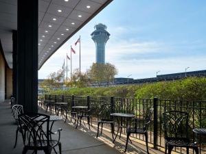 罗斯芒特芝加哥奥黑尔机场希尔顿酒店的一组桌子和椅子,后面有一个控制塔