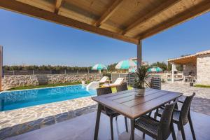 AmbelókipoiMateo & Filipos Luxury Villas的一个带桌椅的庭院和一个游泳池