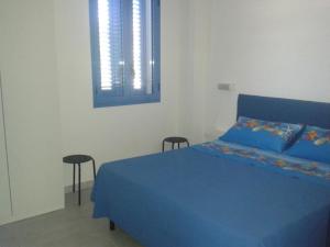卡斯特里尼亚诺德尔卡波Wohnung in Marina Di Felloniche mit Kleinem Garten的一间卧室配有蓝色的床和两把椅子