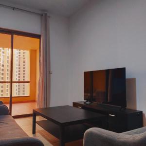 迪拜Sea la Vie的客厅配有电视和茶几