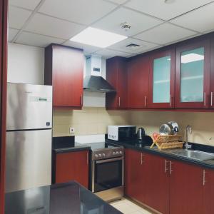 迪拜Sea la Vie的厨房配有红色橱柜和不锈钢冰箱